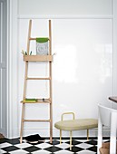 Ladder with shelf on the wall on checkered floor