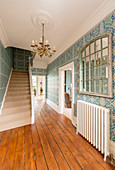 Blue-patterned Art Nouveau wallpaper in hallway with board floor