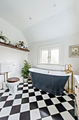 Free-standing bathtub made of riveted metal in classic bathroom