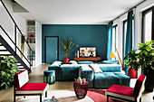 Blue sofa combination and red easy chairs in open-plan living room