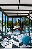 View from modern conservatory onto roof terrace with view of city