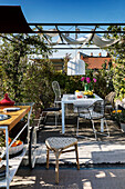 Esstisch auf überdachter Dachterrasse im Sommer