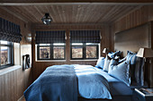 Schlafzimmer im Cottage mit Holzwänden und niedriger Deckenhöhe