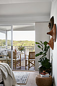 Ethno-Wanddekoration und Zimmerpflanze im Schlafzimmer mit Balkon