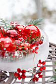 Red Christmas baubles in ice bowl with fairy lights