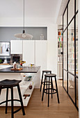 Zeitgenössische Küche in Weiß-Schwarz abgetrennt vom Wohnbereich durch raumhohe Glaswand