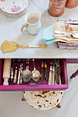 Silver cutlery in open drawer of kitchen table