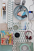 Renovation utensils: paint sample cards, can of paint, book and headphones