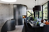Set dining table in black, open-plan interior with fireplace