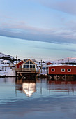 verschneide Häuser am winterlichen Fjord in Norwegen