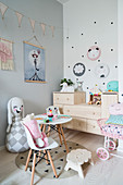 Soft toy's tea party in girl's bedroom in pastel shades