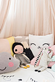 Soft toys and cushions under pink canopy