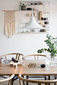 Designer lamp above wooden table in Scandi-style dining room