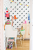 Golden chair at old desk in child's bedroom with horse-patterned wallpaper