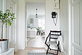 Stuhl im Flur mit Altbau-Charme vor der Tür zum Schlafzimmer