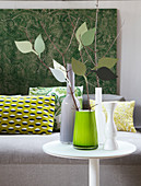 Wohnaccessoires im grünen Natur-Look: Wandbehang, Kissen und Dekozweige in Vase