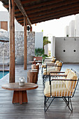 Lounge furniture on roofed terrace next to pool