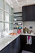 Kleine moderne Küche im Loftstil mit schwarzen Metall-Schrankfronten