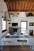 Wohnzimmer im toskanischen Stil mit Esstisch, Kaminecke und Holzdecke