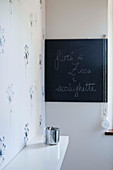 Dandelion-patterned wallpaper and chalkboard in corner