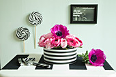 Pink flowers in black-and-white striped tin