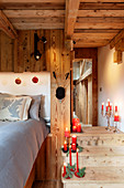 Weihnachtlich dekorierte Holztreppe im Schlafzimmer eines Chalets