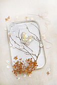 Old tin decorated with twigs, lace and butterfly made from mother-of-pearl buttons