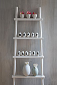 Easter arrangement of white eggs decorated with lettering reading 'Happy Easter' on ladder shelves