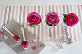 Romantic arrangement of deep pink ranunculus and butterflies