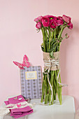 Bunch of deep pink ranunculus and romantic butterfly decorations