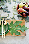 Fig leaf used as name card on wooden board next to place setting