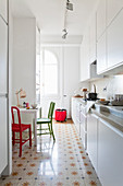 Küchenbereich mit weißer Küchenzeile abgetrennt durch deckenhohe Raumteilerregale