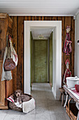 Dog in basket in rustic hallway with wood-clad walls and ceiling