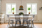 Grey spoke-back chairs around table in country-house-style dining room