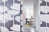 Tree-patterned wallpaper on wall and door leading into kitchen