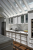Light-flooded kitchen with skylights and white cabinets
