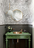 Green washstand with copper sink in guest toilet with grey walls