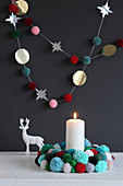 Christmas wreath and garland of pompoms against black wall