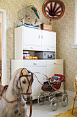 Rocking horse, kitchen dresser and vintage accessories in child's bedroom