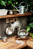 Pans, cake tins and kitchen utensils in outdoor play kitchen