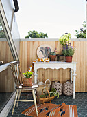Accessories on old chair and console table on sunny inverted dormer roof terrace