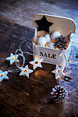 Baubles, pine cones and star-shaped fairy lights in vintage china salt cellar