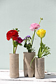 Selbstgemachte Vasen aus Beton mit Ranunkeln, Ageratum und Anemone