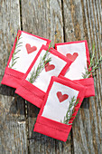 Hearts printed on paper with pinked edges tucked into linen napkins