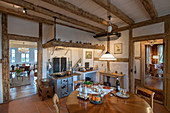 Round table in open-plan kitchen with rustic half timbering