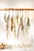 Handmade feathers made from patterned paper hung from rod