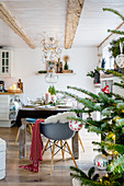 Christmas tree and set dining table in open-plan interior