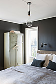 Locker-style wardrobe in bedroom with black walls
