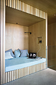 Modern alcove seat with pale wooden panelling in architect-design house