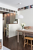 Dining table next to open doorway with half-height partition wall in apartment interior